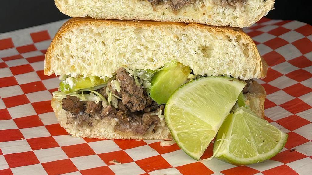 Carne Asada Torta · Carne asada, black beans, cabbage, our red sause, cilantro and onions