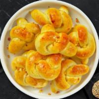 Devil'S Garlic Knots · Our house made pizza dough, knotted up, baked, then smothered in real garlic butter and parm...