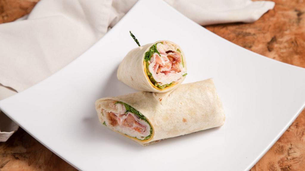Classic Club Wrap · Black forest ham, oven classic turkey, bacon, Vermont yellow cheese, lettuce, tomato and mayo served on our flour tortilla.