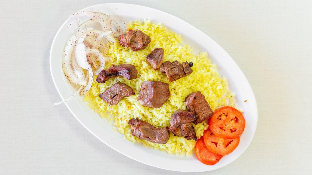 Beef Kebab · A skewer of seasoned rib eye steak char-broiled to perfection, served with rice, fresh slices of tomatoes and onions, pita bread and garlic sauce.