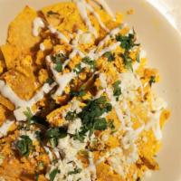 Chilaquiles · Corn tortilla wedges, salsa verde and salsa roja, chorizo, scrambled egg, queso fresco, crema.