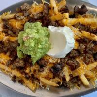 Asada Fries · Crispy french fries topped with beans, shredded cheese, carne asada, homemade-guacamole, & s...