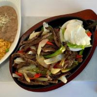 Steak Fajitas · Marinated beef sautéed with fresh bell peppers & onion. Served with rice, refried pinto bean...