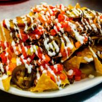 Super Nachos · Carne asada, grilled chicken, pastor or ground beef. Served with melted shredded cheese. Tom...
