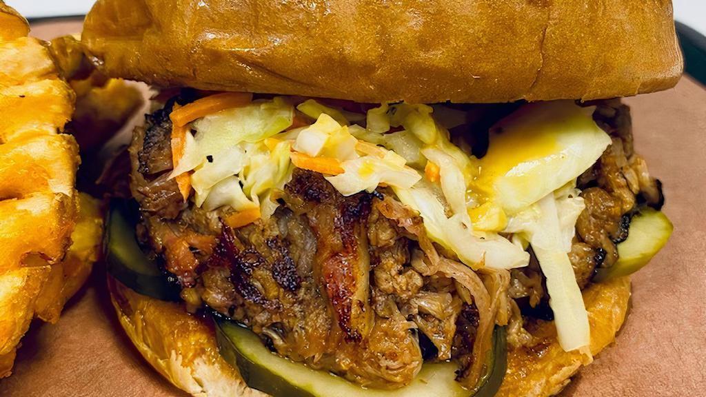 Pulled Pork Sandwich · Toasted Brioche bun, incredible smoked sauced ＆ seasoned pulled pork shoulder, Tangy Vinegar and Carolina Gold sauces, jalapeño-IPA pickles, topped with our house vinegar slaw.