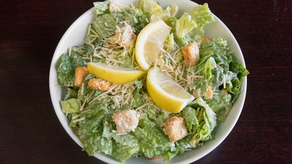 Caesar Salad · Romaine lettuce tossed with caesar dressing, croutons, lemon, and parmesan cheese.