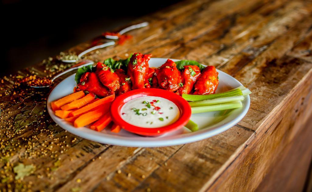 Chicken Wings · Spicy. Chicken wings tossed in buffalo wing hot sauce and garlic butter. Served with celery, carrots and ranch dressing for dipping.