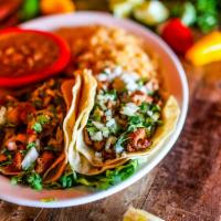Tacos Al Pastor · Gluten-free. Two soft corn tortillas filled with marinated diced pork, topped with chopped o...