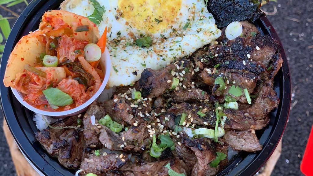 Bulgogi Rice Bowl · Grilled marinated bulgogi beef over a bed of jasmine rice, topped with fried egg over nori, served w/a side of homemade kimchi, then sprinkled with furikake rice seasonings.