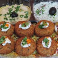 Falafel Over Rice Plate · Chick peas mixed with herbs, served with hummus, tahini sauce, salad and pickles. Rice, tzat...