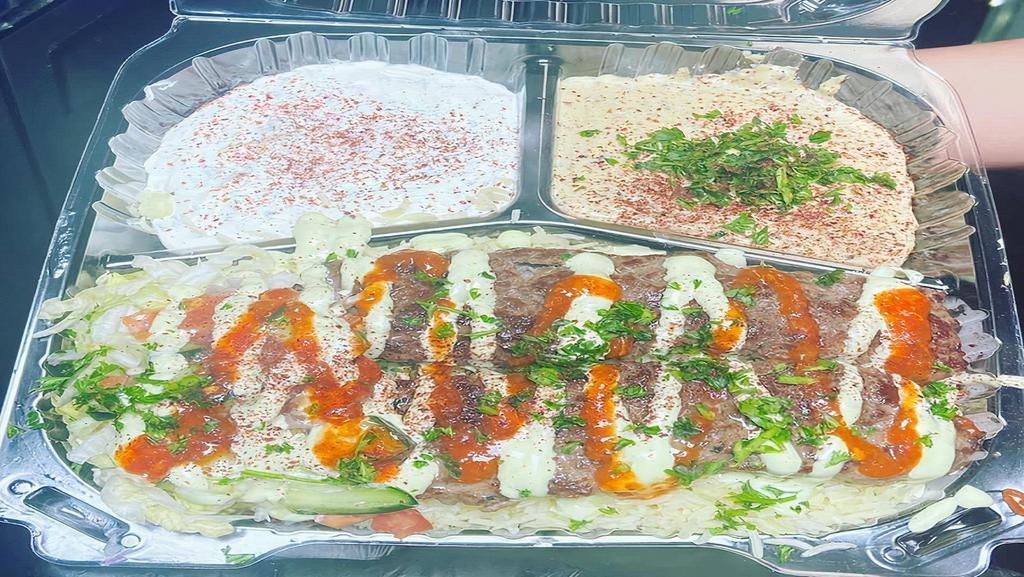 Beef Kabab Over Rice Plate · Beef, rice, mix salad, tzatziki, hummus mix spicy garlic sauce.
