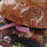 Brisket · Slow smoked slice brisket served on a base of chimichurri, topped with bbq sauce, and pickle...