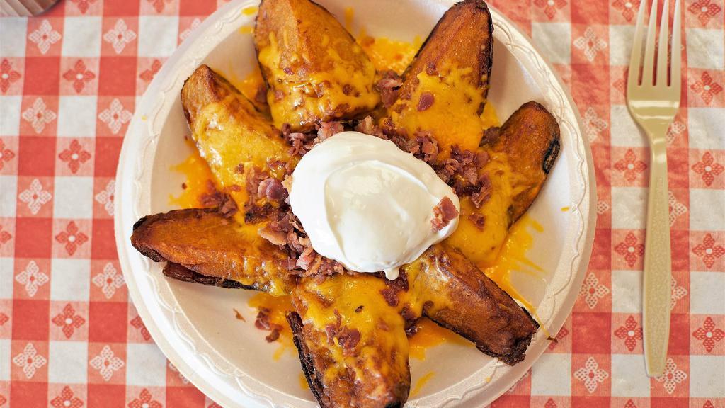 Potato Skins · Topped with sour cream, bacon bits, and cheddar cheese.