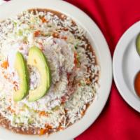 Tostada · Crispy corn tortilla layered with pinto beans, cabbage, shredded carrot, tomatoes, onion, so...