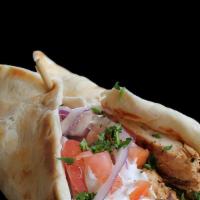 Chicken Shawarma Pita (Halal) · Chicken shawarma in a pita bread with hummus, lettuce, tomatoes, onion, and tahini sauce.