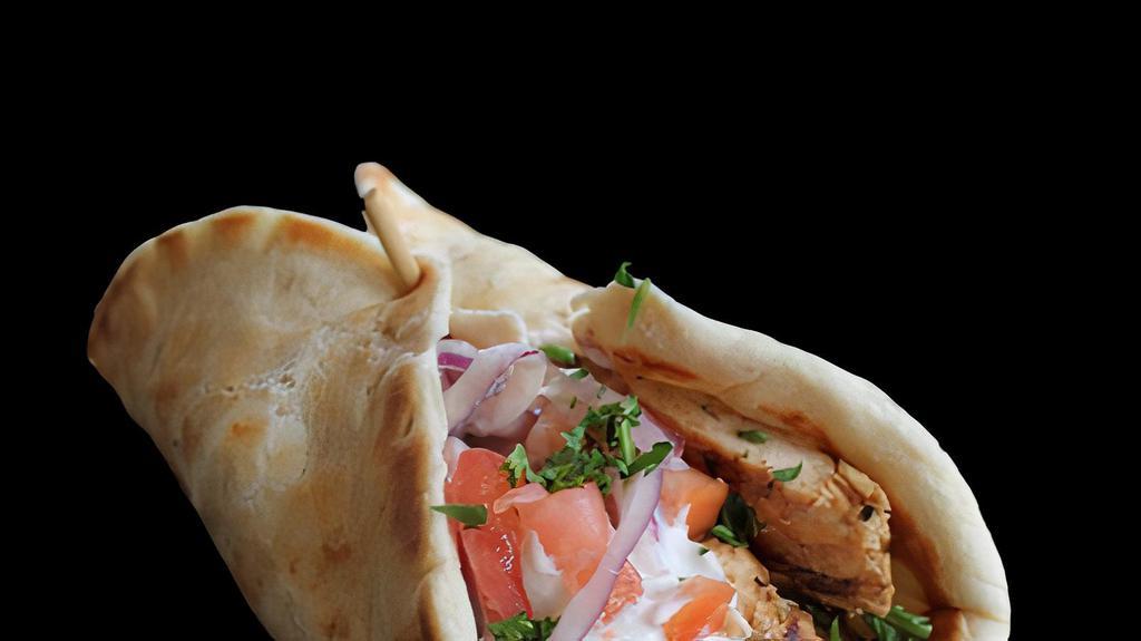 Chicken Shawarma Pita (Halal) · Chicken shawarma in a pita bread with hummus, lettuce, tomatoes, onion, and tahini sauce.