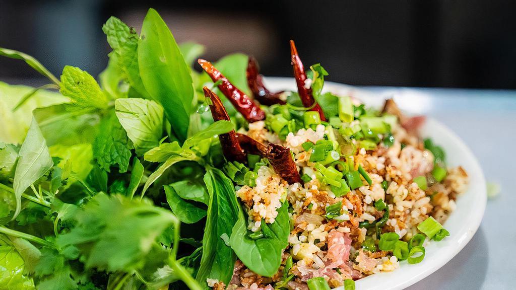E8 Nam Khao Tod · Crispy fried pork and rice salad loaded with flavor. List of ingredients including chopped peanuts, sliced scallions, shallots, mint, cilantro, lime juice, fish sauce, curry, and more. Contain peanut.