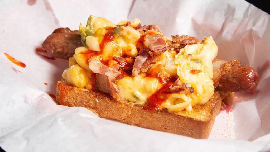 505 Dog · Buttered Brioche Bun With Premium All Beef Nathans HotDog, Wrapped In Center Cut Bacon, Topped With 4 Cheese Mac&Cheese, Bacon Bits, Green Chilli, Red Chilli Sauce.