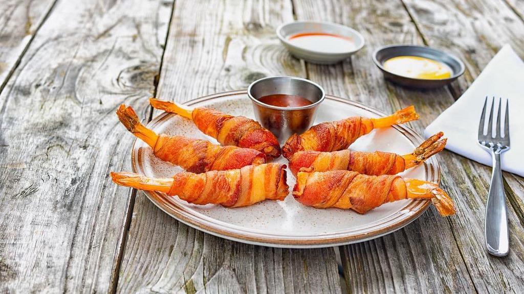 Bacon Wrapped Prawns · Our signature jumbo prawns wrapped on bacon and fried to perfection. Served with sweet chili sauce.