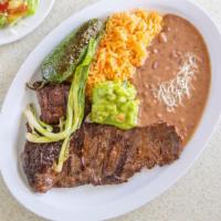 Carne Asada · Strips of broiled steak with rice, beans, salad, and tortillas.