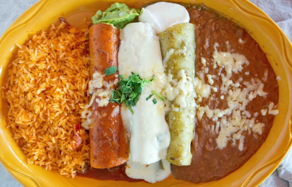 Plato Bandera Combo · Brillant flavors and the colors of the Mexican flag with three enchiladas. Green chile verde pork, chile rojo beef, blanca sauce chicken, all topped with melted cheese, garnished with sour cream and guacamole. Served with beans, melted cheese and Mexican rice.