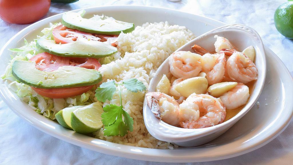 Camarones Al Mojo De Ajo · Gluten free. Succulent shrimp sautéed with butter and garlic cloves. Served with rice, crisp lettuce, tomatos and ripe avocado slices. Your choice of Flour or our hand-made corn tortillas.