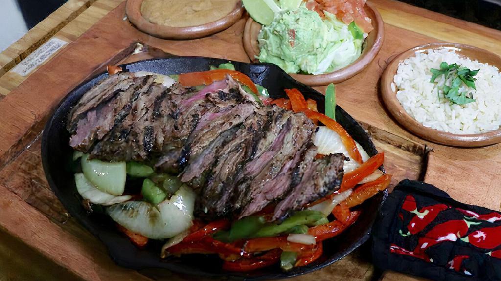 Steak Fajitas Combo (New) · Steak fajitas served sizzling hot on a bed of sauteed onions, peppers, mushrooms, and seasoned corn wheels. Our fajitas are served with rice, guacamole, choice of beans (black, pinto, refried), and tortillas.