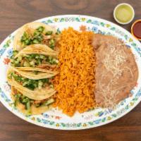 Taco Plate · Four tacos with rice and beans. Topped with cilantro and onions.