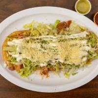 Huarache · Deep fried masa shell with beans and choice of meat. Topped with lettuce, sour cream and che...