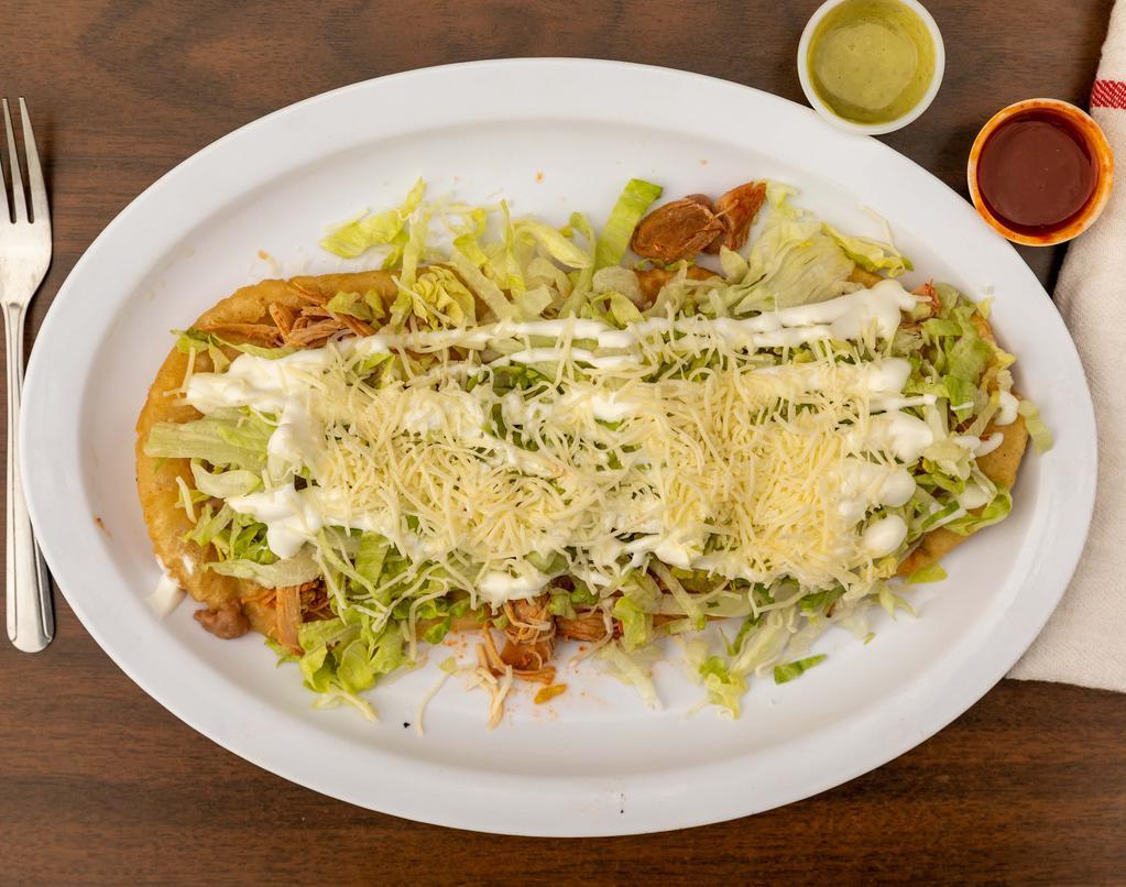 Huarache · Deep fried masa shell with beans and choice of meat. Topped with lettuce, sour cream and cheese.