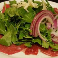 Steak Carpaccio · Tender beef, sliced thin and plated with fresh arugula, Reggiano, capers and olive oil