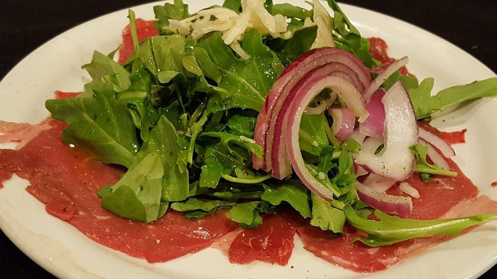 Steak Carpaccio · Tender beef, sliced thin and plated with fresh arugula, Reggiano, capers and olive oil