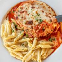 Pollo Parmigiana · Chicken breast topped with melted mozzarella and tomato basil sauce, and served with a side ...