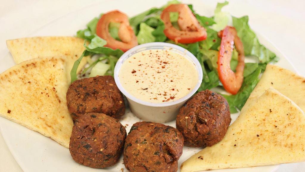 Falafel · Ground chickpeas, fava beans, fresh herbs, and spices, served with pickles and pita bread.