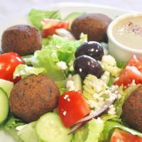 Falafel Salad · greek salad with falafel on the top and Served with pita bread,tahini sauce and dressing
