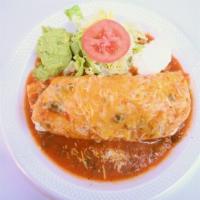 Smothered Burrito · Smothered burrito with lettuce sour cream and avocado on the side