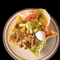 Taco Salad · A crispy flour tortilla shell topped with beans, your choice of meat, lettuce, sour cream, g...