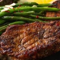Pork Chops · Grilled marinated pork chops served with steamed rice and seasoned green beans topped with p...