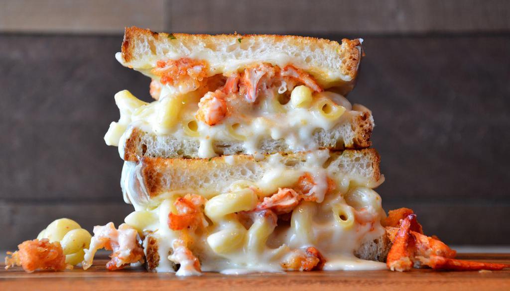 Lobster Grilled Cheese · White cheddar mac and cheese topped with lobster claw meat, provolone and mozzarella cheese on artisan bread with garlic butter.