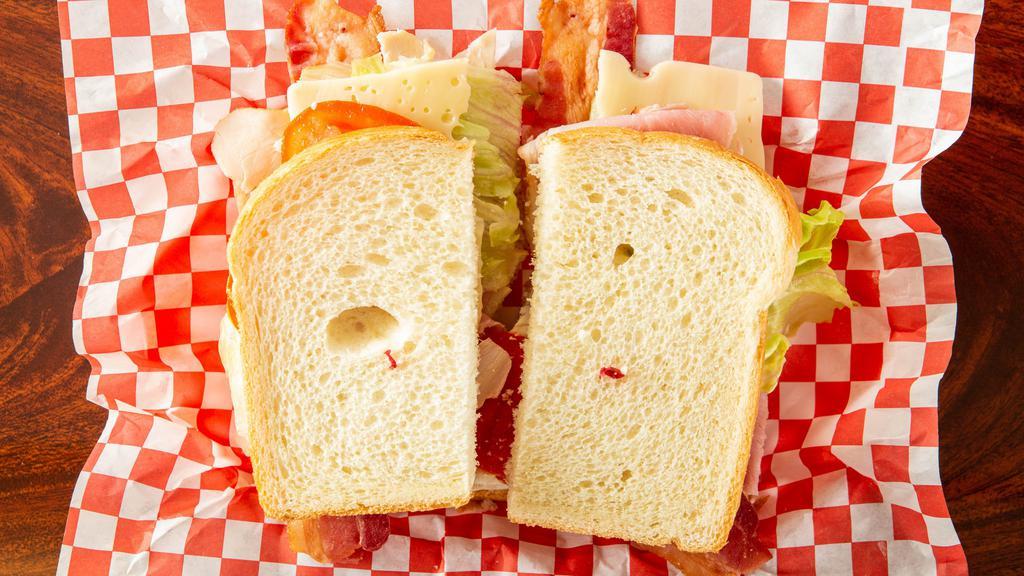Club House Sandwich · Layered with ham , turkey and bacon, mayo, mustard, lettuce, tomato, and swiss cheese.