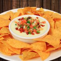 Queso Dip · A delicious salsa made of melted cheeses. Topped with pico de gallo. Served with tortilla ch...