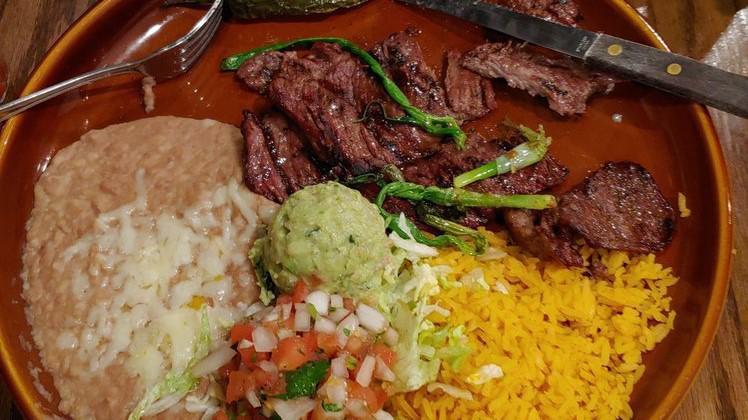 Carne Asada · Skirt steak seasoned and charbroiled to perfection! Served with guacamole. Garnished with Pico de Gallo, fried pepper and green onions.