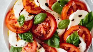 Caprese Salad · Roma tomato, avocado, mozzarella cheese, balsamic reduction, basil pesto dressing.