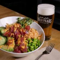 Four Peaks Poke · Ahi tuna toped with green onion & spicy rose sauce over calrose rice with rainbow carrots, c...
