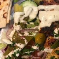 Chicken Kebab · Chicken kebab on top of basmati rice and served with Greek salad, warm pita.