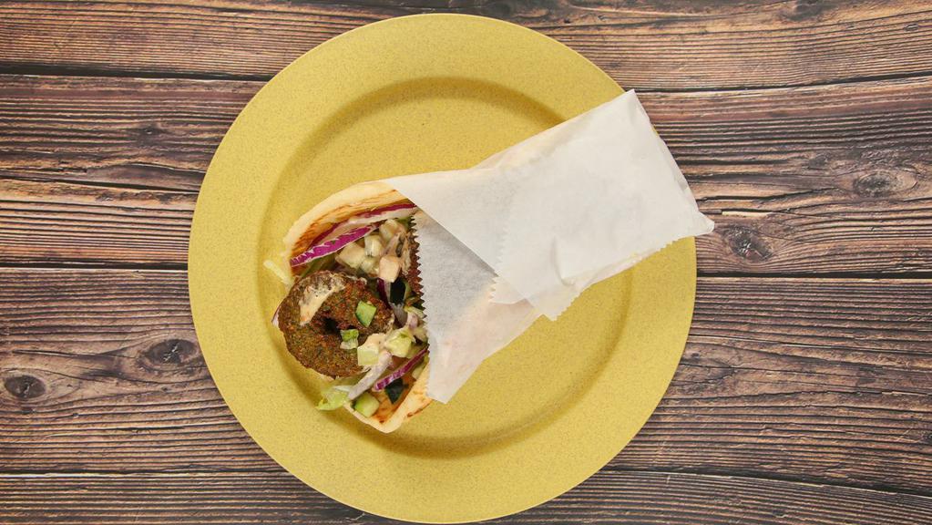 Falafel Pita -  Build Your Own · A vegetarian, dish blend of garbanzo beans, vegetables and seasonings, deep fried and served with lettuce, red onions, chopped cucumbers and tomatoes, and choice of sauce.