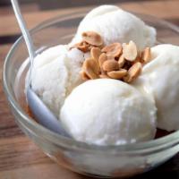 Coconut Ice Cream · Our homemade coconut ice cream mixed with soft young coconut served with roasted peanuts and...