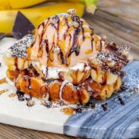 Banana Waffle · Frosted Belgian waffle topped with caramelized bananas, vanilla ice cream, and pecans, drizz...