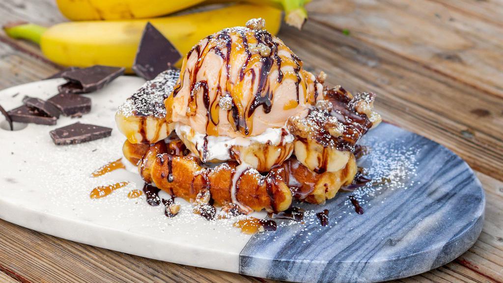 Banana Waffle · Frosted Belgian waffle topped with caramelized bananas, vanilla ice cream, and pecans, drizzled with dark chocolate ganache.