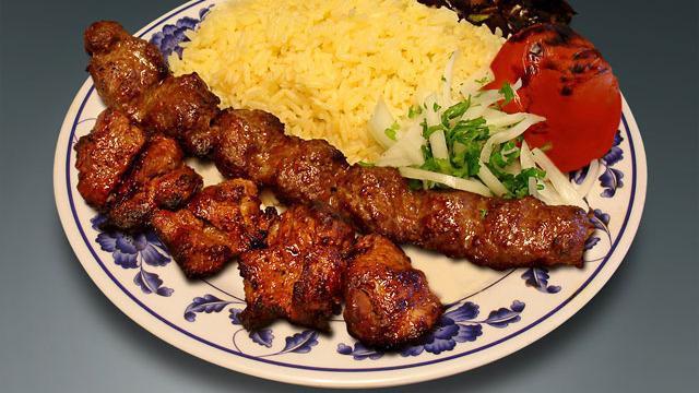. Combo #3 · One skewer of beef lula kebab and one skewer of chicken kebab with rice, a side salad a roasted tomato and jalapeno.